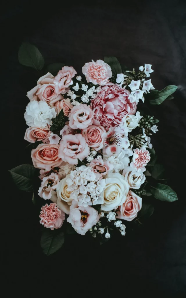 Composition florale élégante de roses et pivoines aux tons rose et blanc.