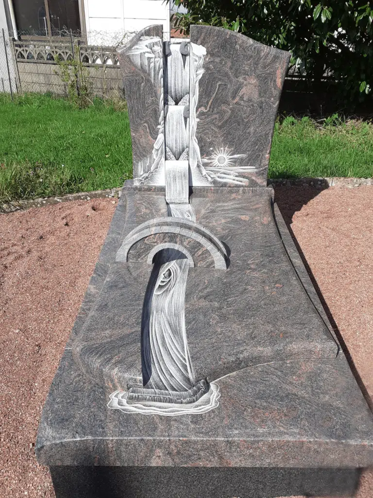Monument funéraire sculpté représentant une cascade et un pont en pierre.